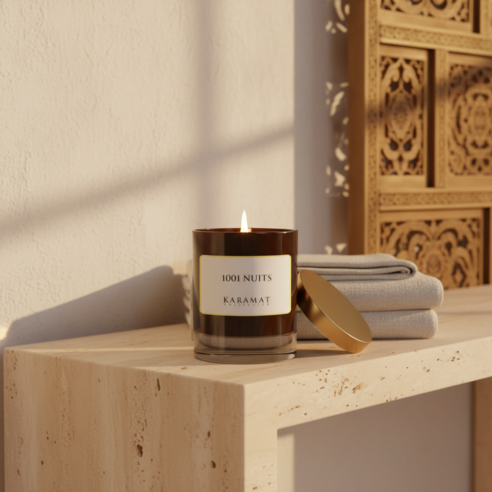 Bougie parfumée 1001 Nuits Karamat allumée sur une console en travertin