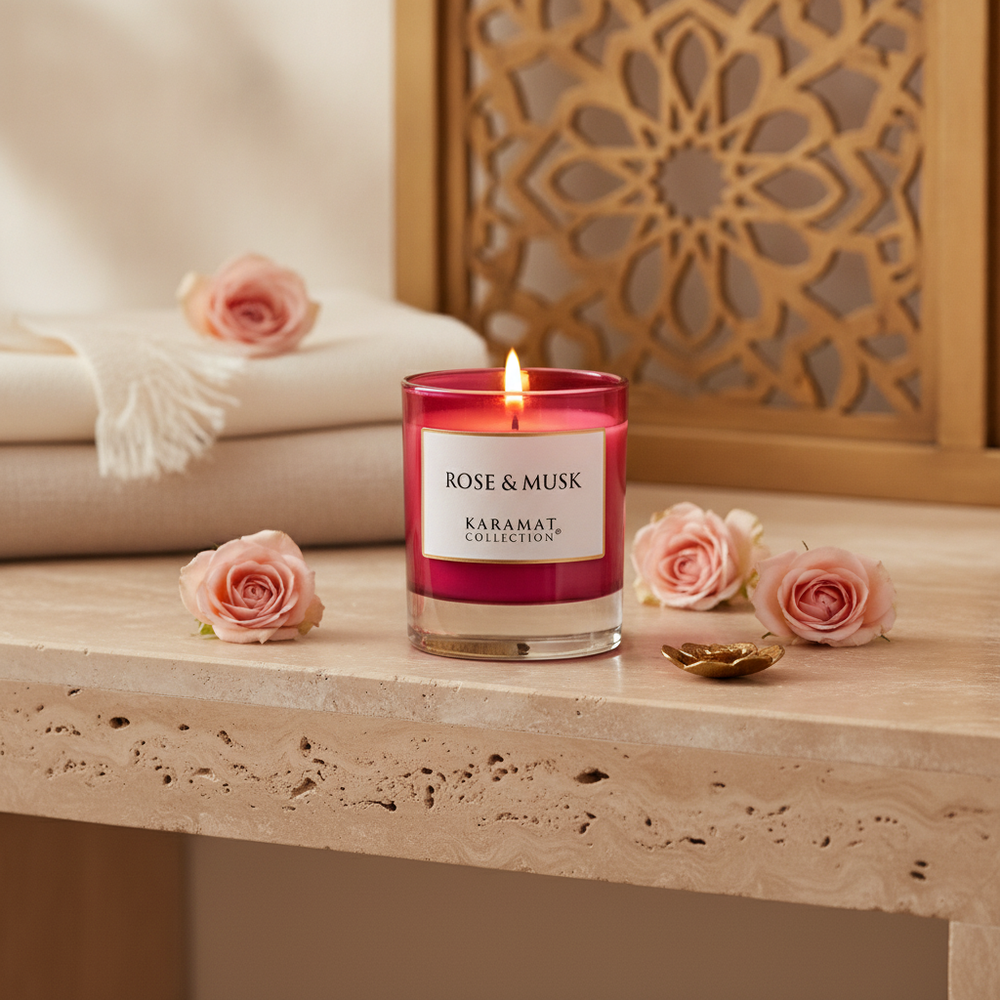 Bougie parfumée Rose & Musk Karamat allumée sur une console en travertin