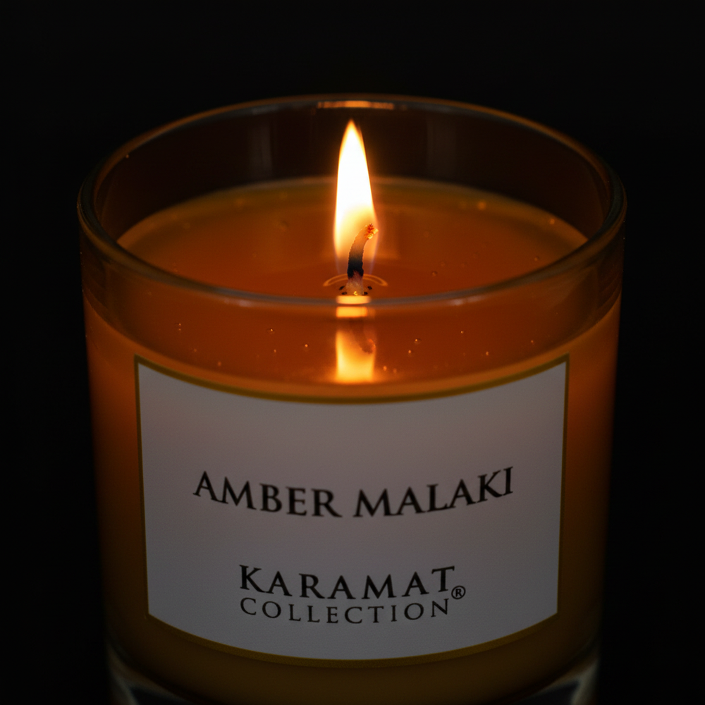 Bougie parfumée Amber Malaki Karamat allumée sur une console en travertin