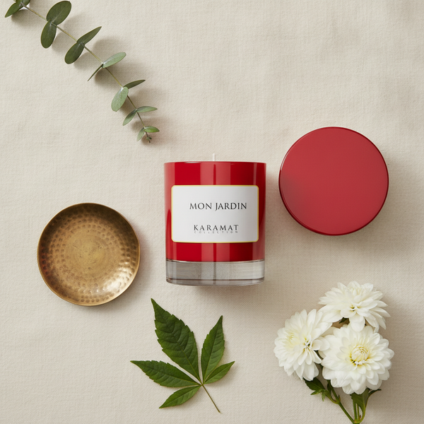 Bougie parfumée Mon Jardin Karamat à plat avec feuillage et fleurs blanches