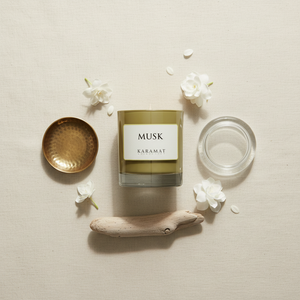 Bougie parfumée Musk Karamat à plat avec fleurs blanches et bois flotté