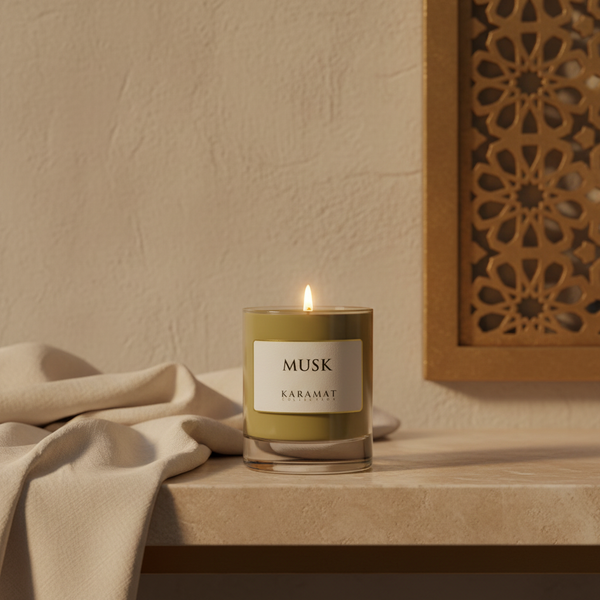 Bougie parfumée Musk Karamat allumée sur une console en travertin