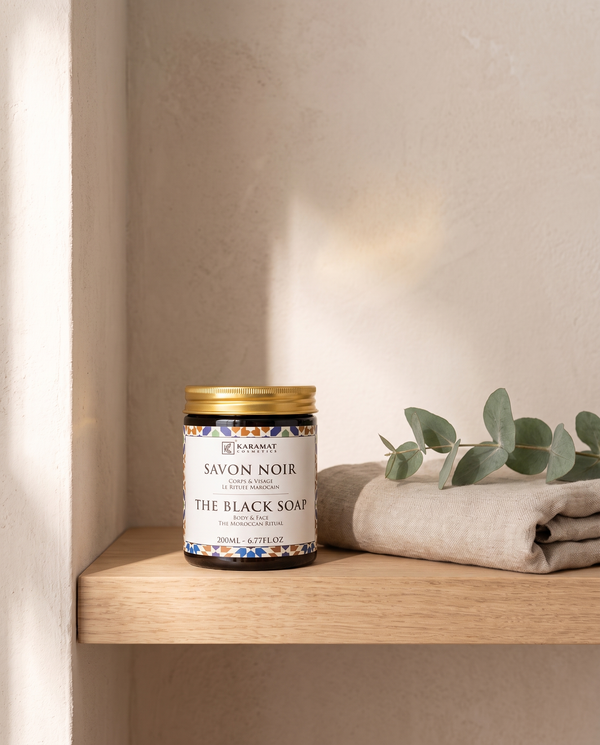 Pot de savon noir beldi 200 ml sur une étagère de salle de bain avec linge et eucalyptus