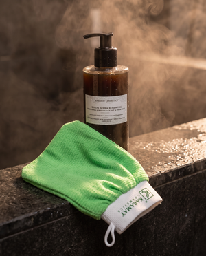 Savon noir liquide marocain 300 ml et gant kessa Karamat Collection sur une margelle de douche